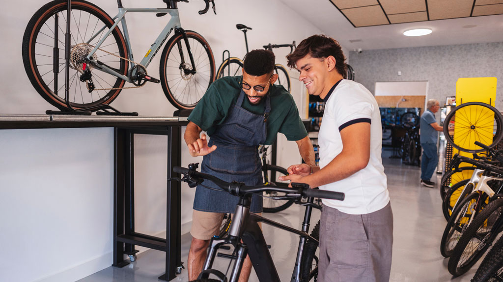 Deux adultes comparant vélo classique et VAE au bord du lac